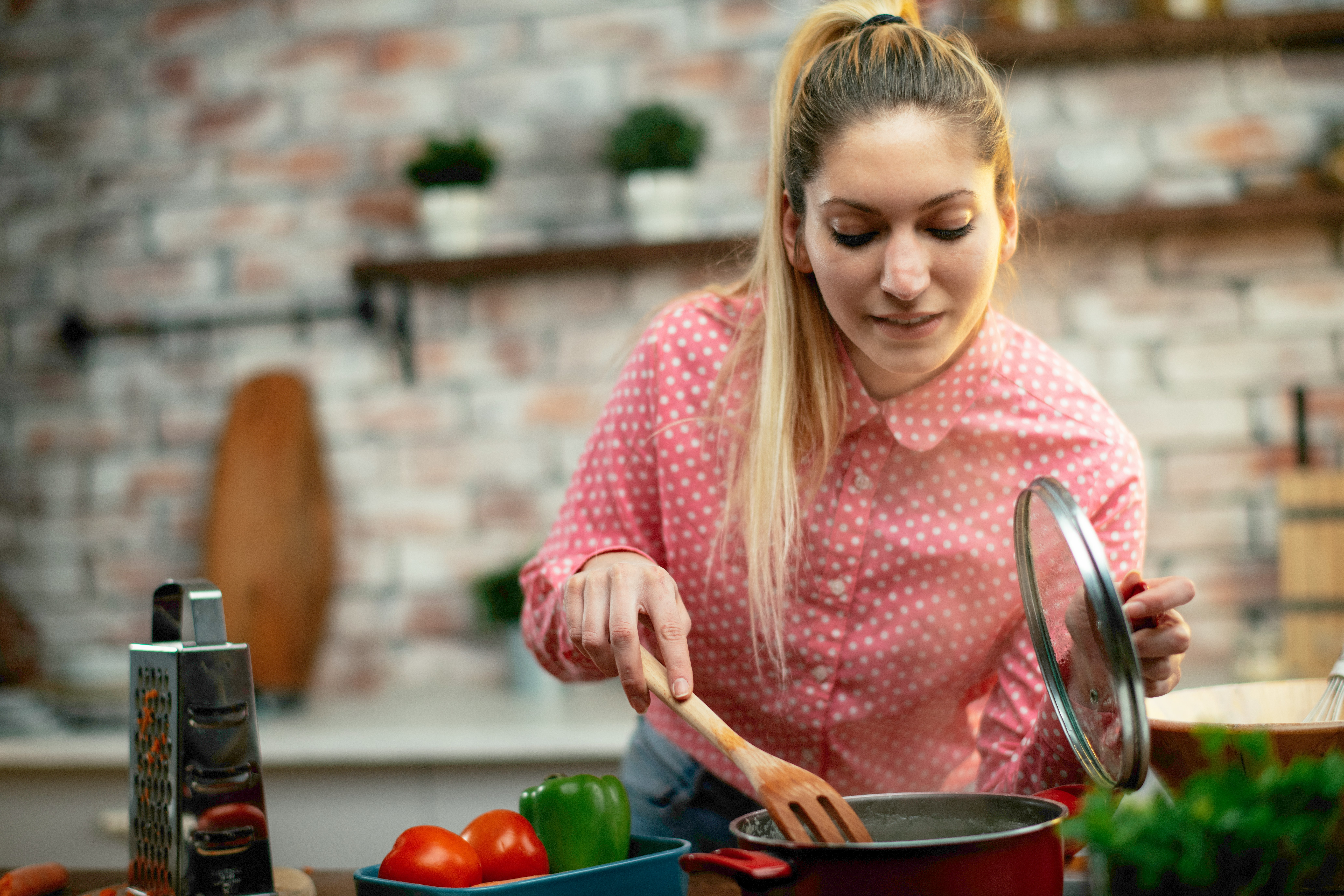 woman cooking protein rich meal helping reduce cravings